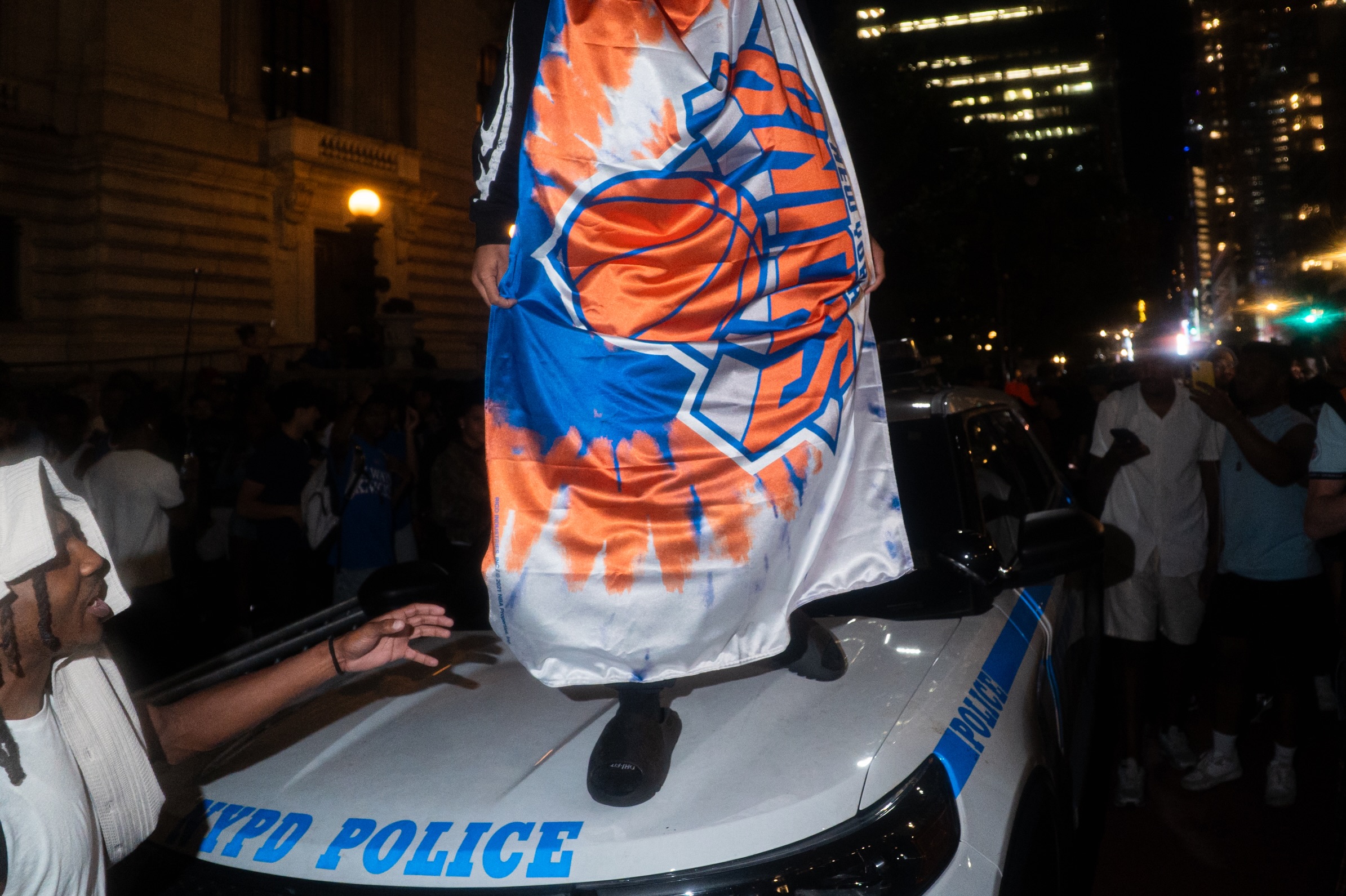 Knicks fans climb NYPD cars outside Madison Square Garden, photograph 1 of 10